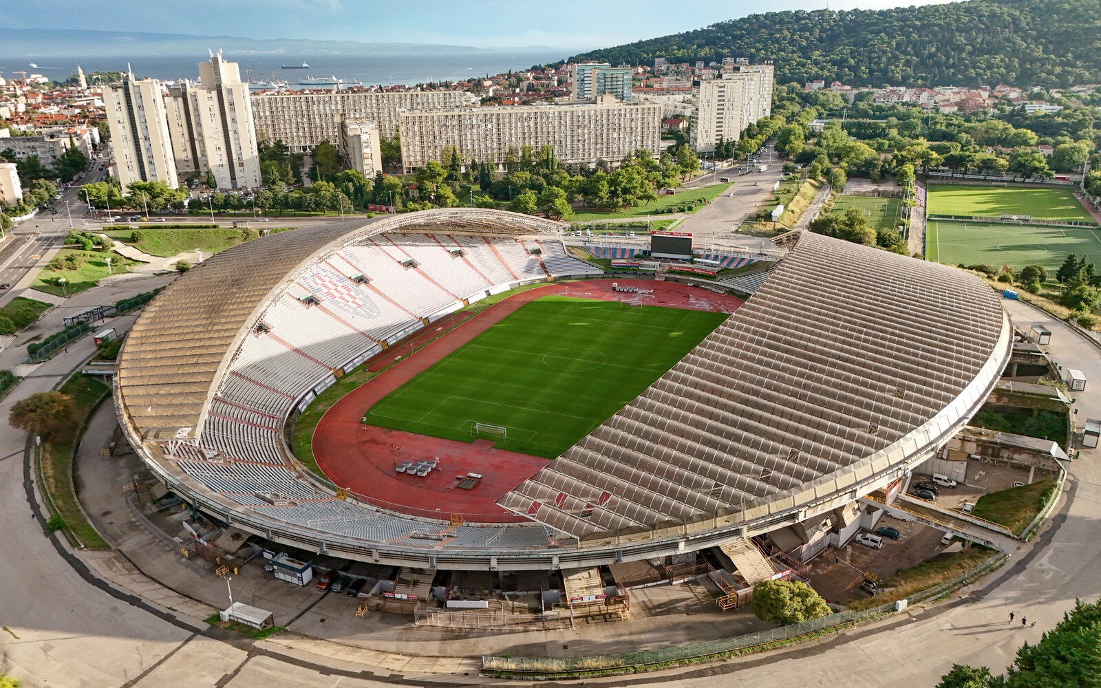 Aerial overview of a large stadium bowl and surrounding city